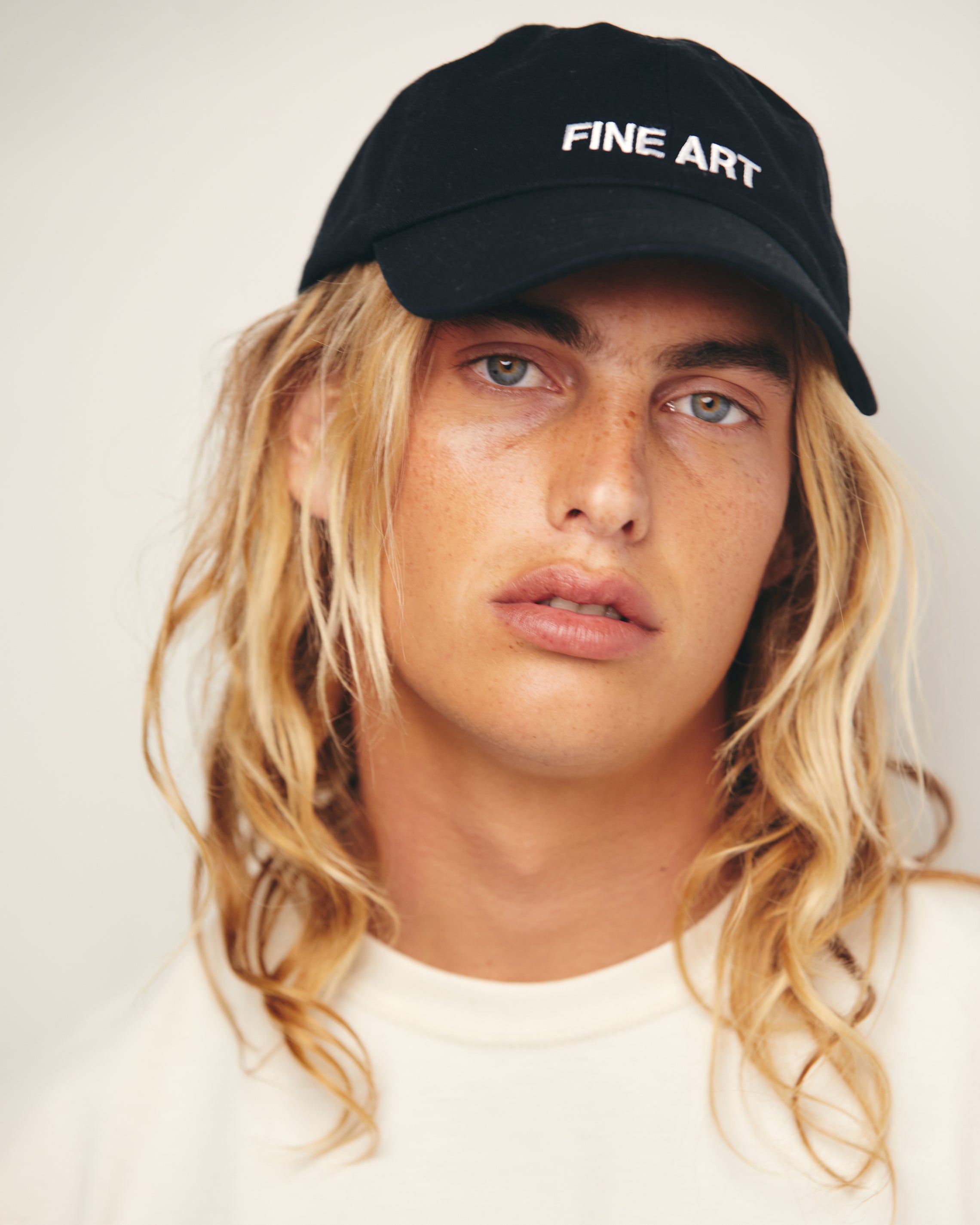 Lucas Ucedo wears Black Baseball Cap / Dad Hat with Fine Art Movement Text Embroidery on Front. 100% Cotton.